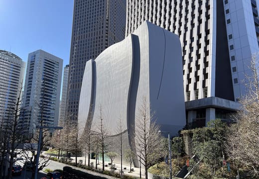 Curved white windowless SOMPO Museum of Art building beside the head office in Nishi-Shinjuku
