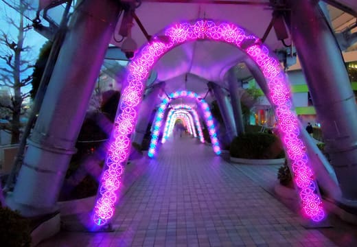 Pink and blue light arches along a walkway at the Tokyo Dome City winter illumination