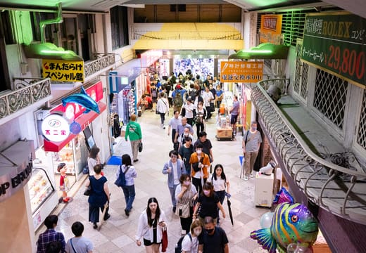 Shoppers in the covered indoor arcade of Nakano Broadway lined with collector shops