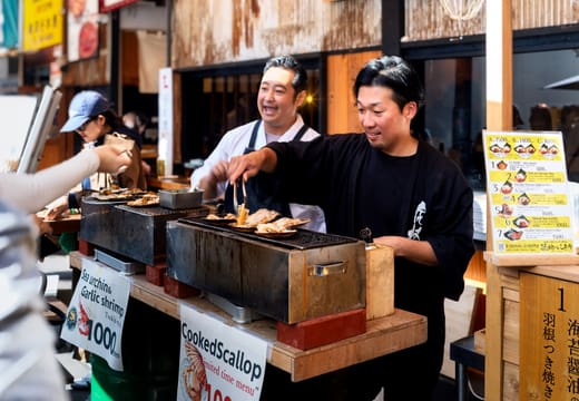 Vendors grilling scallops at a stall in Tsukiji Outer Market, Tokyo, in the morning