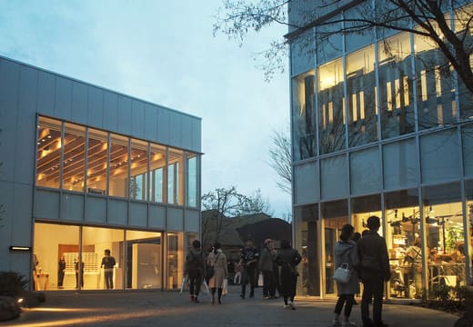 The white lattice pavilions of Daikanyama T-Site lit up at dusk with visitors outside