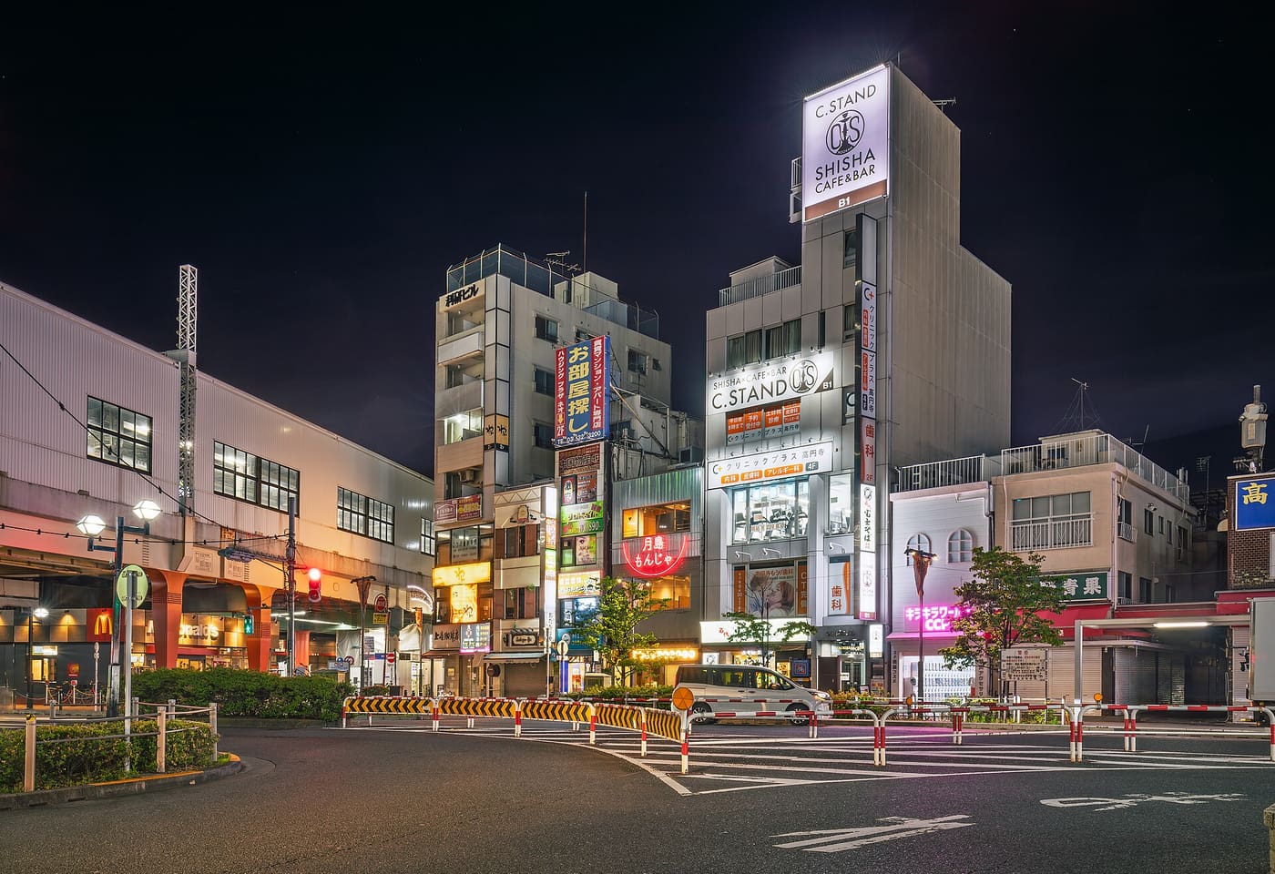 Koenji Station north exit plaza and the surrounding bars and shops lit at night