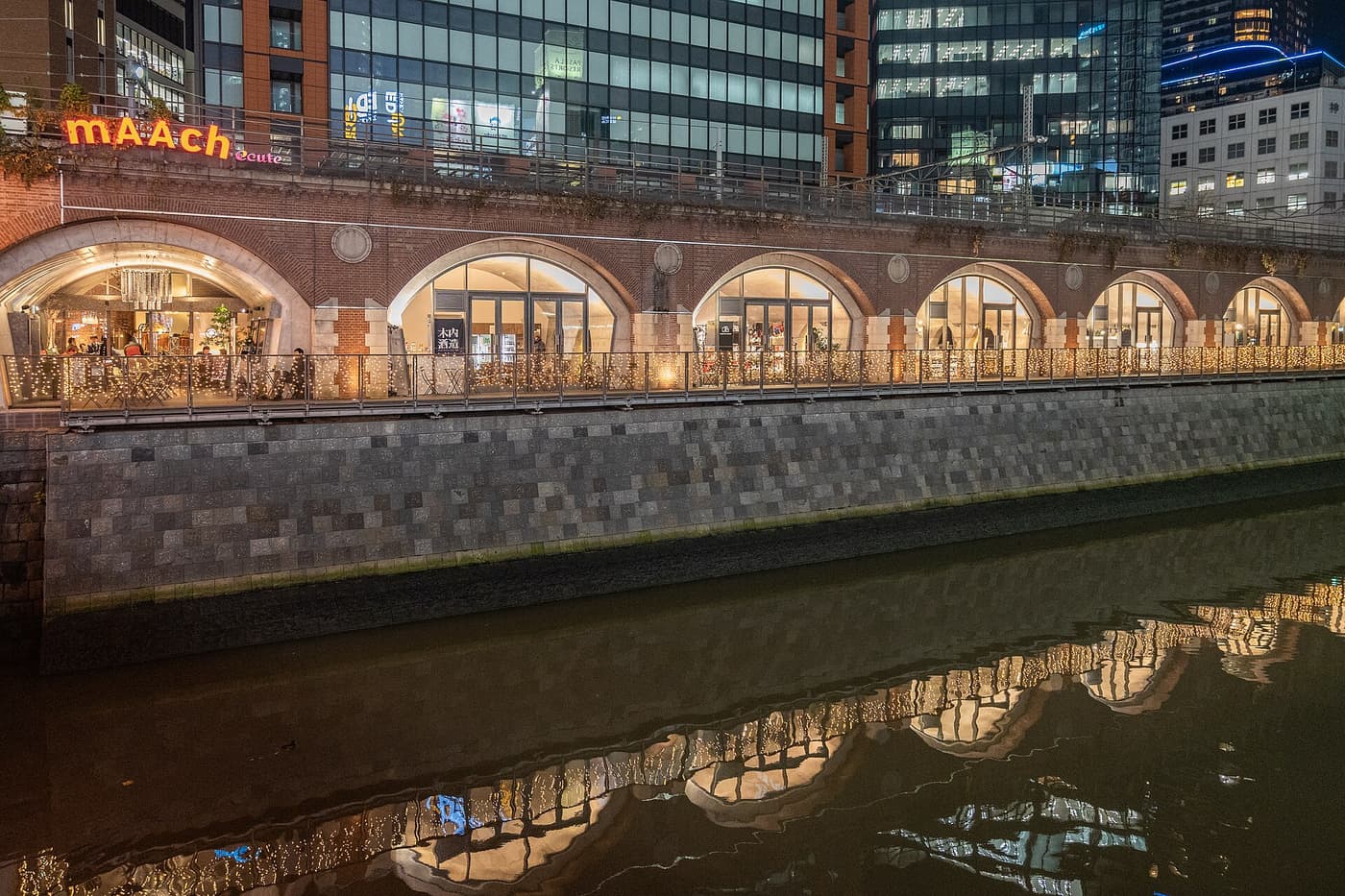 Brick railway arches of mAAch ecute Kanda Manseibashi reflected in the Kanda River at dusk
