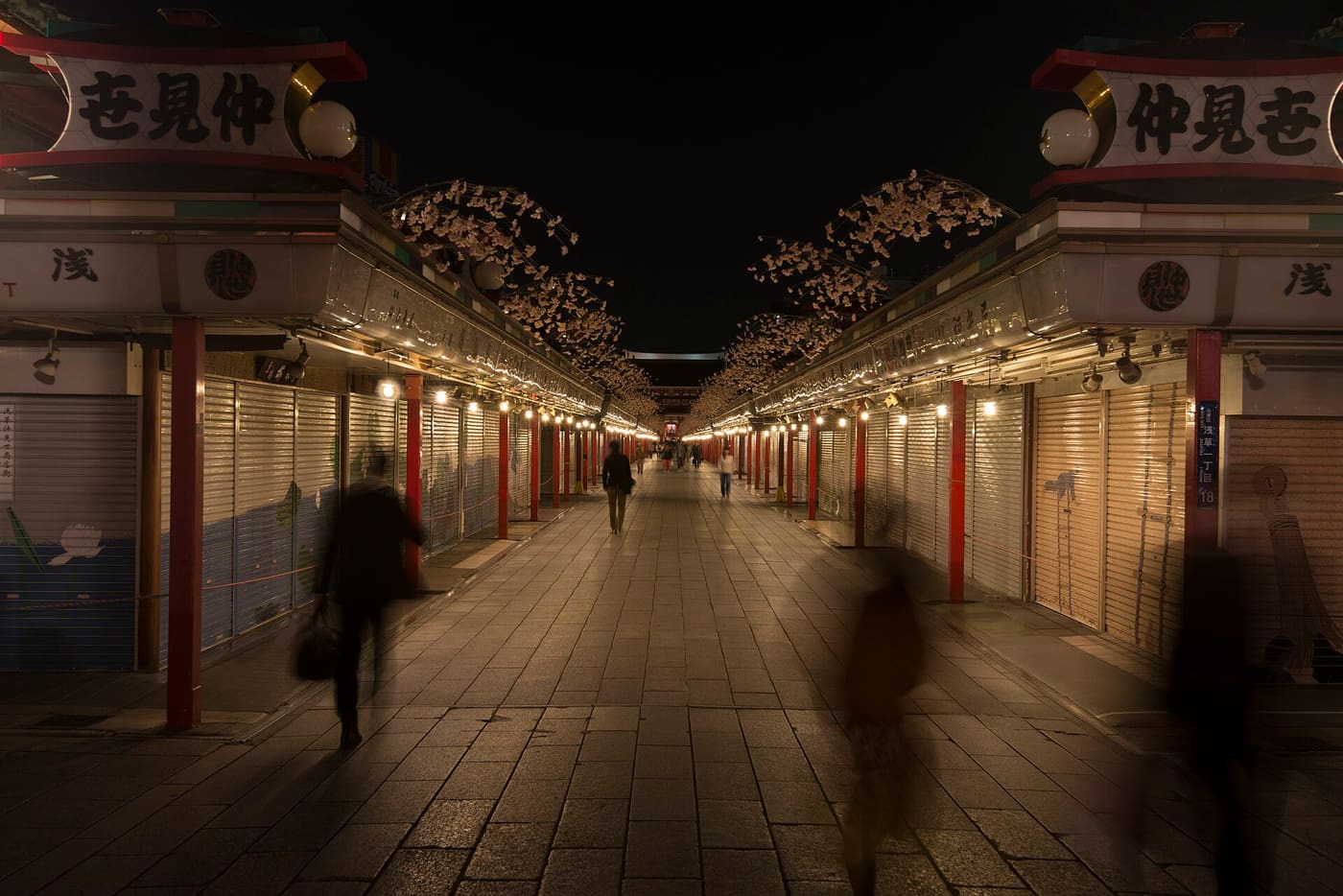 Nakamise Shopping Street after closing, its shuttered snack and souvenir stalls lit at night