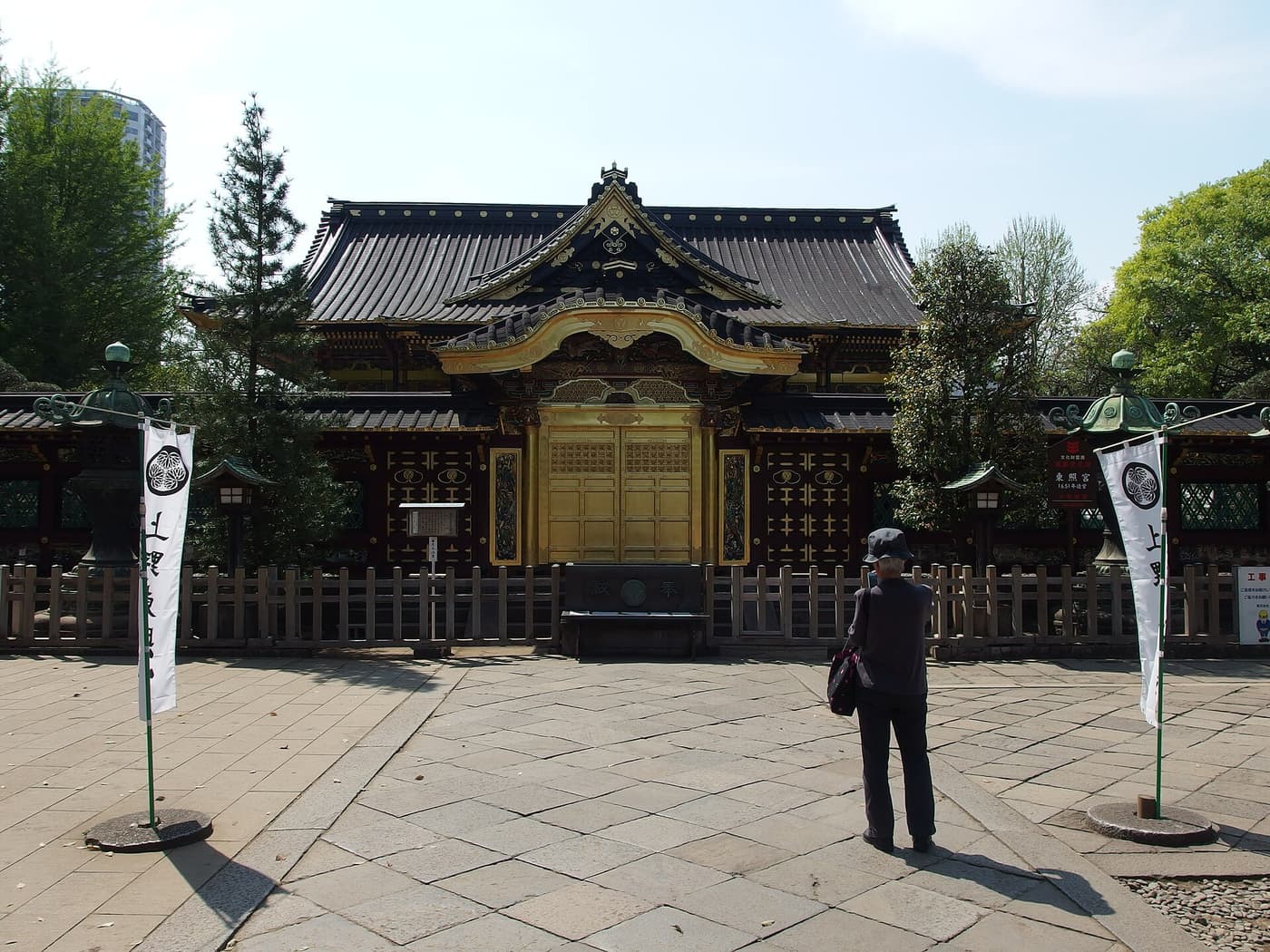 Gilded hall of Ueno Toshogu Shrine seen across its stone courtyard in Ueno Park
