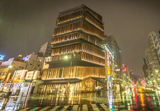 Asakusa Culture Tourist Information Center glowing on a rainy night by Kaminarimon