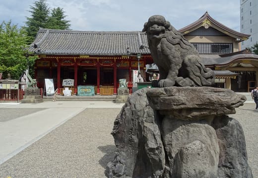 Stone komainu statue on its rock pedestal before the hall of Asakusa Shrine