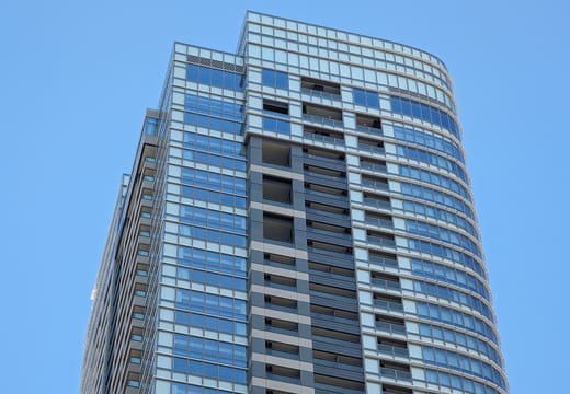 Glass residential tower of Azabudai Hills rising against a clear blue sky