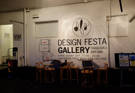 Design Festa Gallery logo wall above the stools of its cafe bar in Harajuku