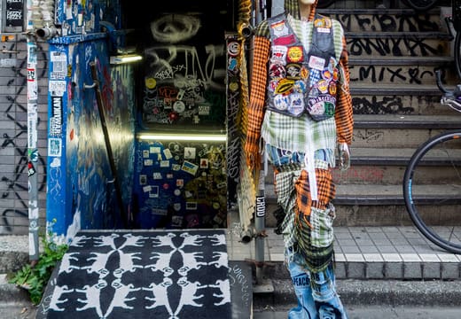 Painted art figure beside the graffiti-covered entrance of Design Festa Gallery, Harajuku