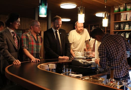 Baristas and guests around the curved coffee bar counter at Fuglen Tokyo, Tomigaya
