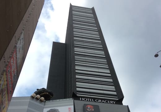 Looking up at the Shinjuku Toho Building with the Godzilla head on its terrace
