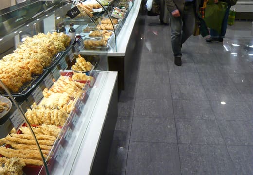 Glass counters of prepared foods lining an aisle of the Isetan Shinjuku basement food hall