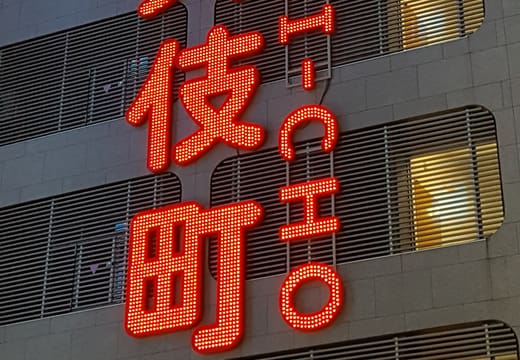 Vertical neon sign declaring love for Kabukicho on a building in the Shinjuku nightlife district