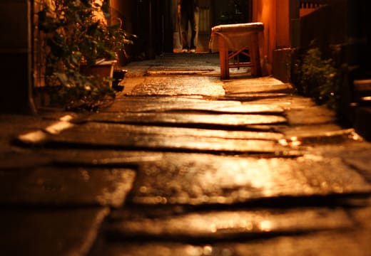 Narrow stone-paved Kagurazaka alley glowing under lamplight at night