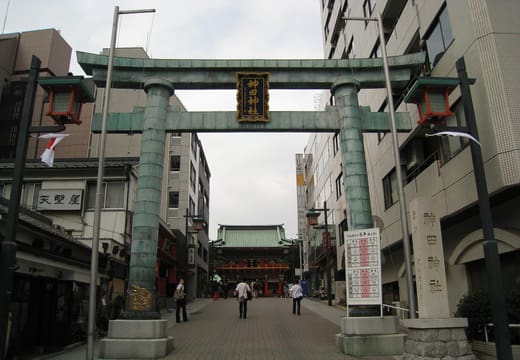Bronze torii at the start of the Kanda Myojin approach with the shrine gate beyond