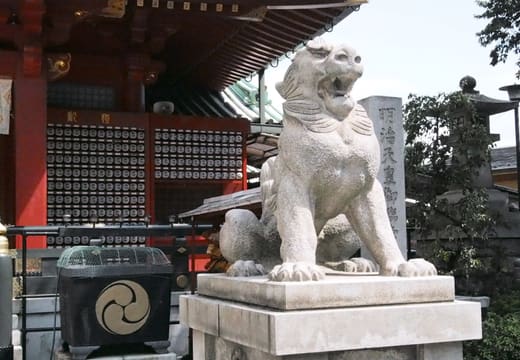 Stone komainu guardian lion with open mouth in front of Kanda Myojin Shrine