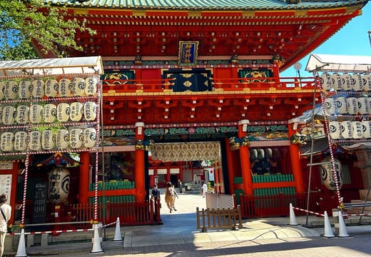 Vermilion and green Zuishinmon gate of Kanda Myojin Shrine under a clear blue sky