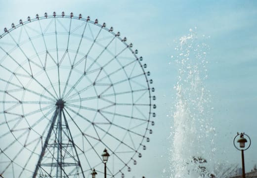 Ferris wheel and fountain spray under a clear sky in Kasai Rinkai Park, Edogawa