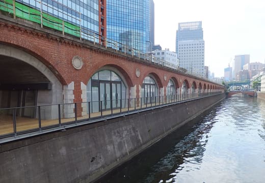 Red brick railway viaduct and riverside deck of mAAch ecute along the Kanda River