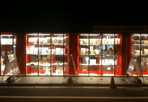 Glowing red display windows full of collectibles at Mandarake Complex in Akihabara