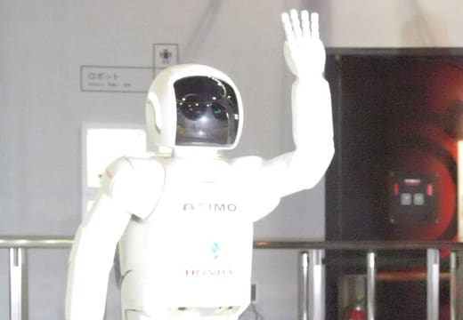 Honda ASIMO humanoid robot raising a hand on display at Miraikan, Odaiba