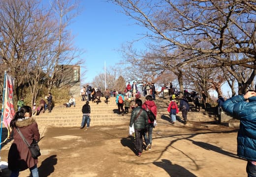 Hikers crowding the summit plaza of Mt Takao on a clear winter day