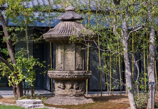 Carved stone lantern among the trees of the Nezu Museum garden in Aoyama