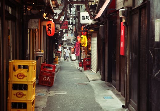 Omoide Yokocho alley by day with beer crates stacked outside the shuttered stalls