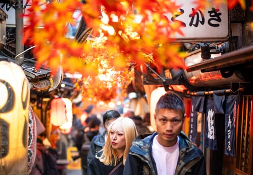 Autumn leaf decorations and lanterns above night drinkers in Omoide Yokocho, Shinjuku