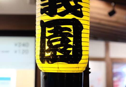 Yellow paper lantern painted with the name Rikugien hanging at the garden entrance