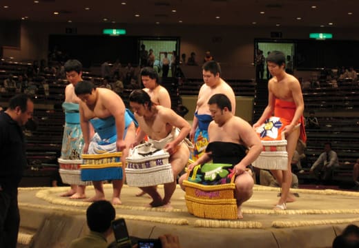 Sumo wrestlers in ceremonial aprons during the ring-entering ceremony at Ryogoku Kokugikan
