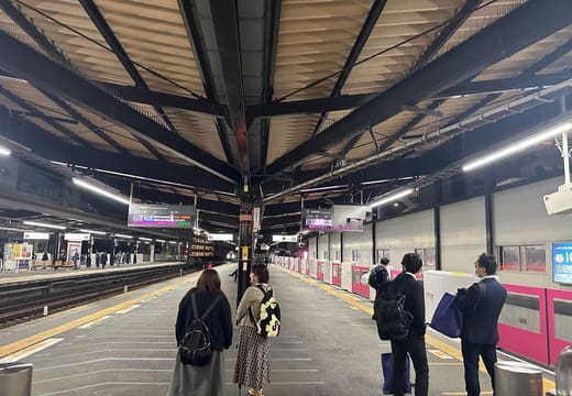 Commuters waiting on the elevated Keio Line platforms at Sasazuka Station at night