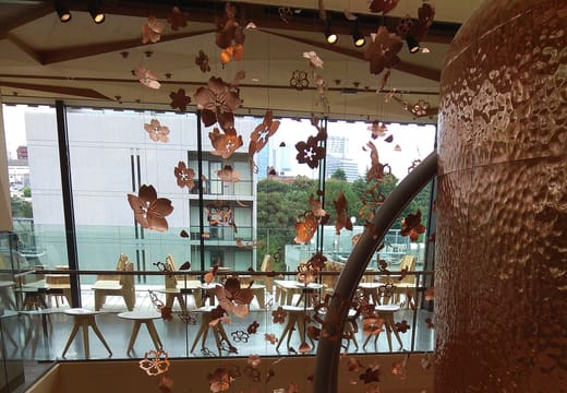 Copper coffee cask hung with paper cherry blossoms rising through the Roastery floors, Nakameguro