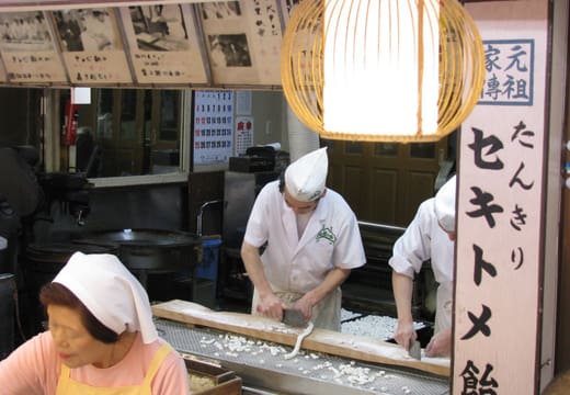 Candy makers chopping tankiri ame sweets at an old shop on Taishakuten Sando, Shibamata