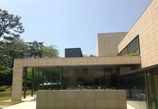 Glass and stone annex building of the Tokyo Metropolitan Teien Art Museum among trees