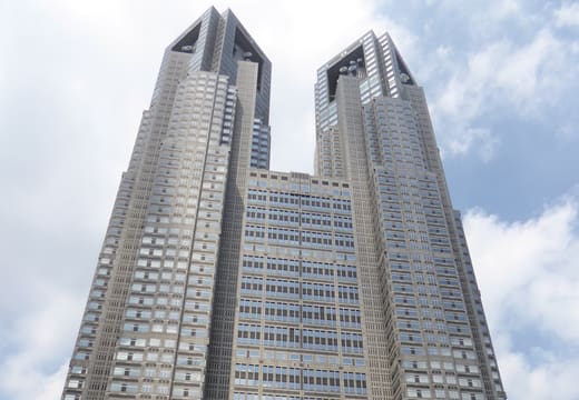 Twin towers of the Tokyo Metropolitan Government Building against a blue sky in West Shinjuku