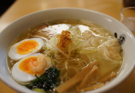 Bowl of clear shio ramen with egg and bamboo shoots served on Tokyo Ramen Street