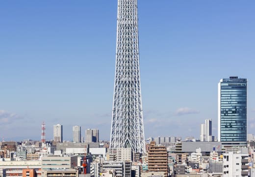Full height of Tokyo Skytree rising into a clear blue sky above Sumida