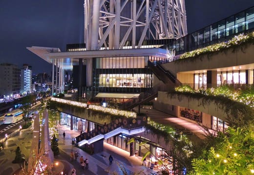 Lit terraces and shops of Tokyo Solamachi at night beneath Tokyo Skytree