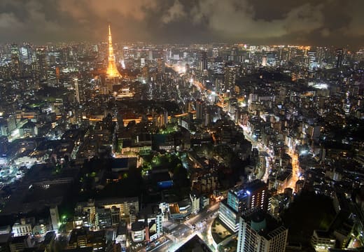Tokyo Tower glowing among the lights of central Tokyo in a wide night cityscape