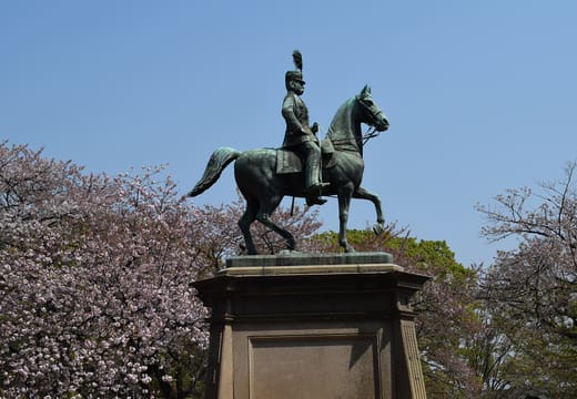 Equestrian statue of Prince Komatsu Akihito framed by cherry blossoms in Ueno Park