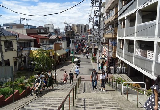 Yuyake Dandan steps looking down onto the Yanaka Ginza shopping street on a sunny day