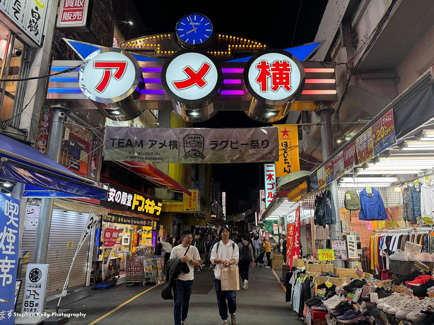 Night shoppers under the neon arch of the Ameyoko market street in Ueno
