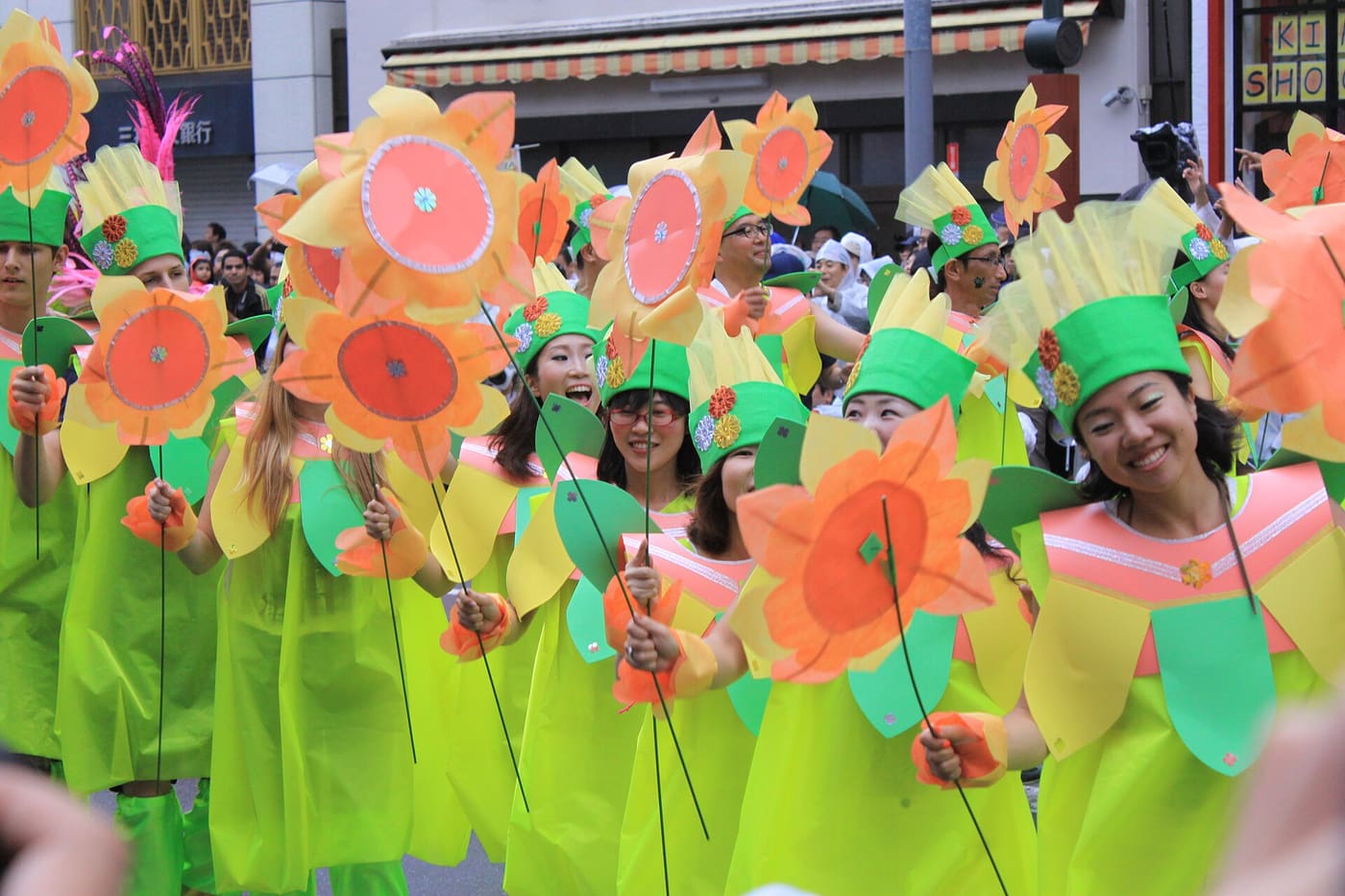 A samba team in green and orange sunflower costumes on the Asakusa parade route