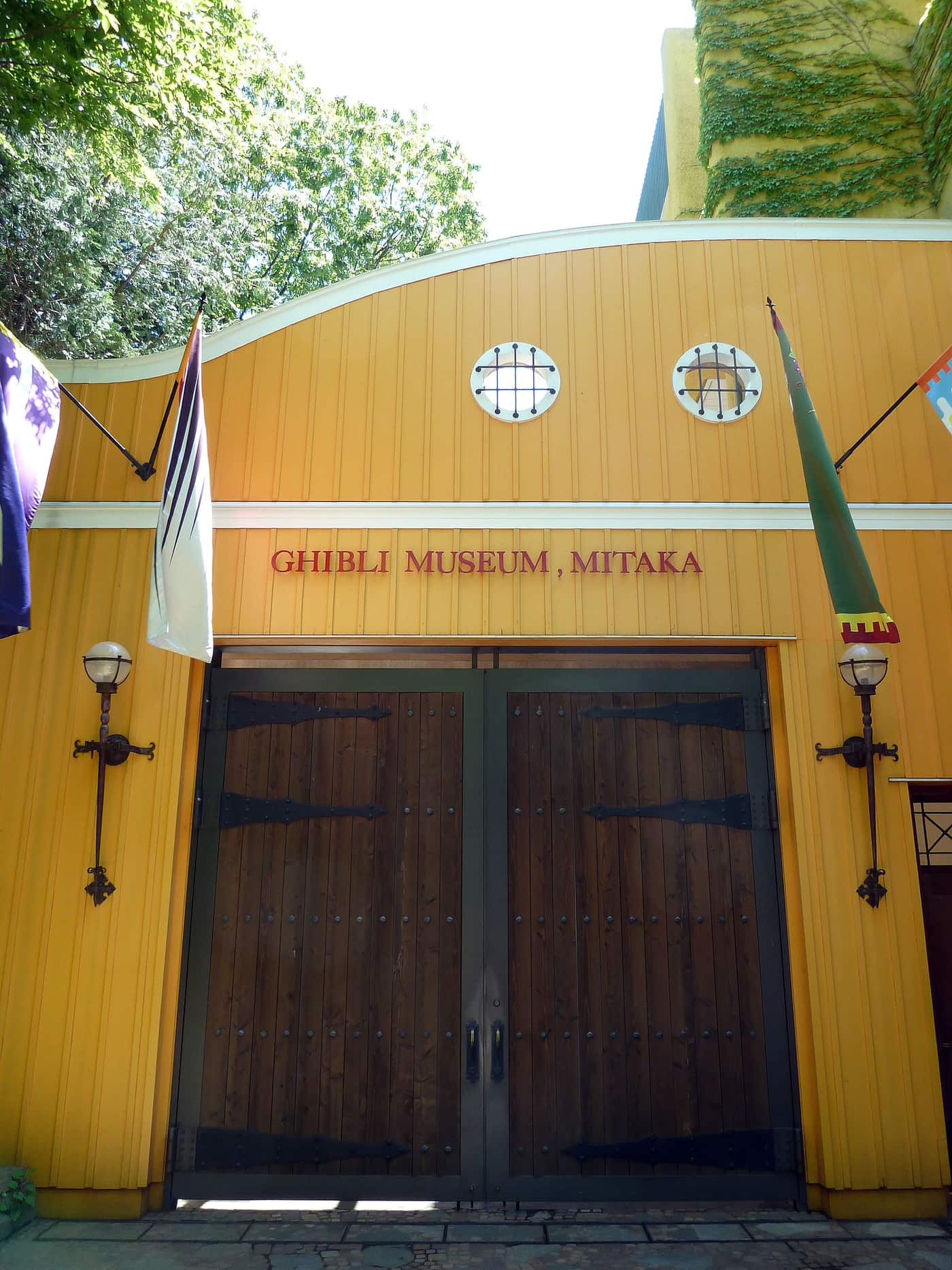 The yellow entrance gate of the Ghibli Museum in Mitaka with its painted sign