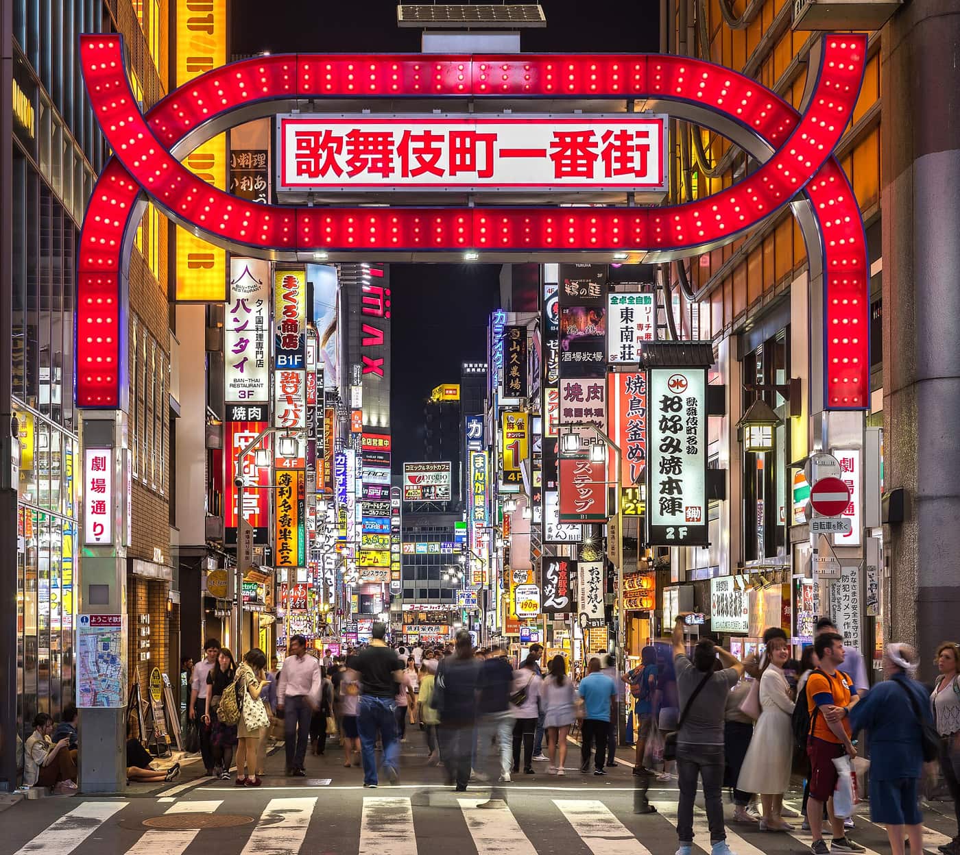 The red Kabukicho Ichibangai gate and neon signs at night on the east side of Shinjuku