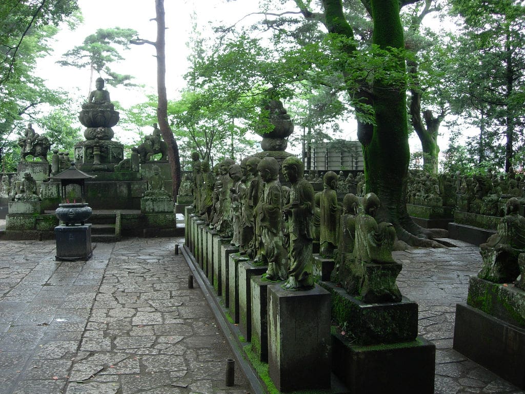 Rows of weathered stone rakan statues in the Gohyaku Rakan garden at Kitain, Kawagoe