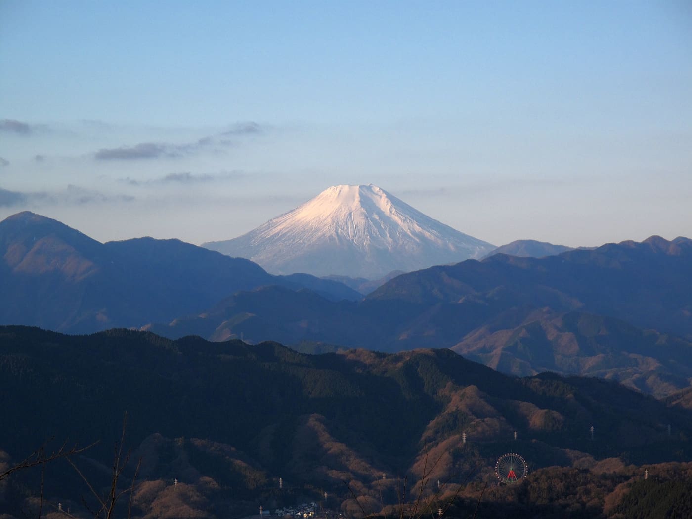 Snow-capped Mount Fuji seen across the ridges from near the summit of Mount Takao