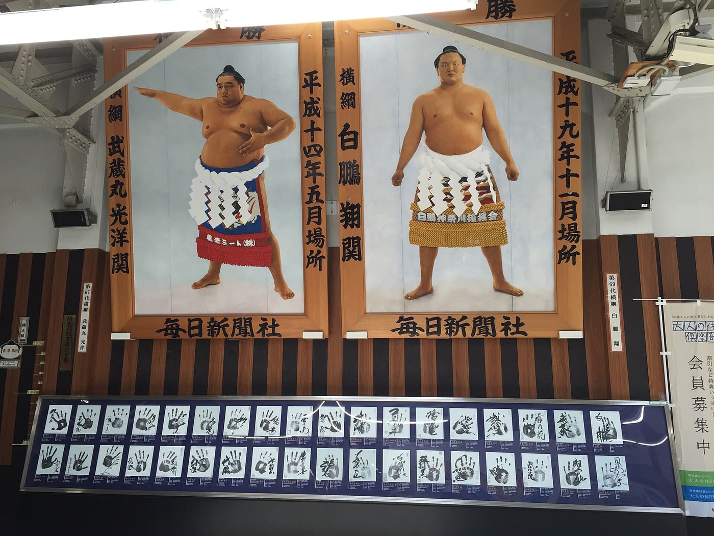 Yokozuna portraits above a row of sumo wrestlers' handprints on display inside JR Ryogoku Station